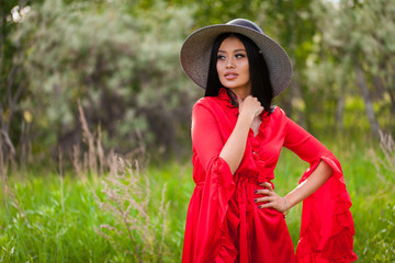 Happy young asian woman in hat on a nature