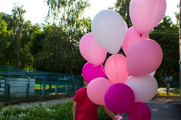 boy holds in his hand a lot of colored balloons