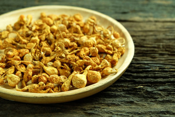 Dried cordyceps militaris in wooden dish on old wooden floors