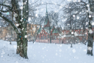snowfall in the city park of Helsinki and view of the German church through the snow flakes