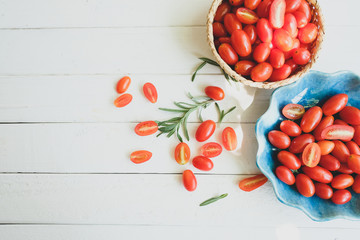 Fresh tomatoes and rosemary on a white background.