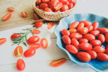 Fresh tomatoes and rosemary on a white background.