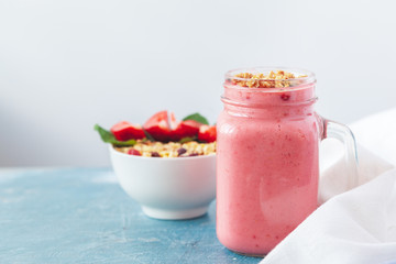 Bowl of homemade granola with yogurt and fresh berries on wooden background