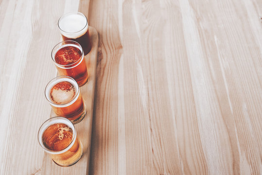 Beer tasting. Diferent beer in 100 mililiter glases over wooden table. Cross-processed. Vintage style. Instagram filter.