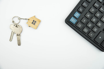 Buying a house, building repair and mortgage concept. Estimation real estate property with loan money and banking. Plan of a house, keys and calculator on white background. 