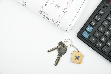 Buying a house, building repair and mortgage concept. Estimation real estate property with loan money and banking. Plan of a house, keys and calculator on white background isolated. 