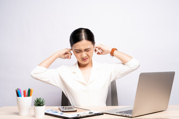 Woman putting a finger into her ear at office isolated white background