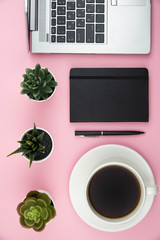Obraz na płótnie Canvas Modern office desk workspace with coffee cup, notebook, laptop and succulent with copy space on trendy pink background. Top view. Flat lay. Education, freelance and business concept