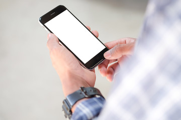 Cropped shot view of man hands holding smart phone with blank copy space screen for your text message or information content, female reading text message on cell telephone during in urban setting.