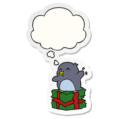 cartoon penguin on present and thought bubble as a printed sticker