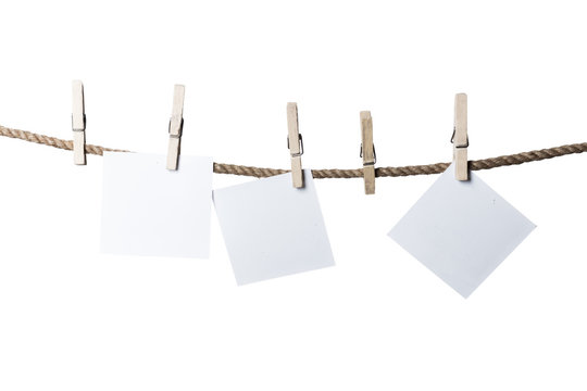 Blank pieces of paper and clothespins isolated on white