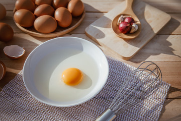 Eggs lay on wooden trays and have broken eggs.