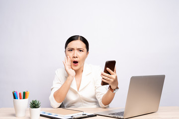 Woman look at smartphone and make gossip gesture at office isolated over background
