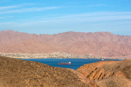 Gulf of Aqaba Red sea bay Middle East scenery landscape photography from drone in wilderness desert sand stone rocky country side area with view on a water and cargo ship in natural frame
