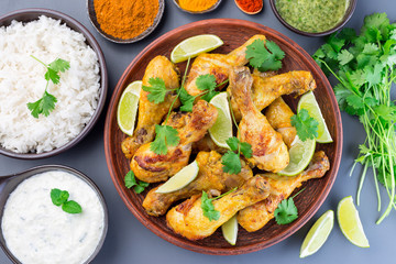 Indian chicken tandoori, marinated in greek yogurt  and spices, served with lime wedges and cilantro, horizontal,  top view