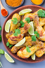 Indian chicken tandoori, marinated in greek yogurt  and spices, served with lime wedges and cilantro, vertical,  top view