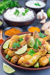 Indian chicken tandoori, marinated in greek yogurt  and spices, served with lime wedges and cilantro,  vertical