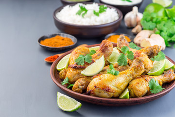 Indian chicken tandoori, marinated in greek yogurt  and spices, served with lime wedges and cilantro, horizontal,   copy space