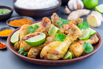 Indian chicken tandoori, marinated in greek yogurt  and spices, served with lime wedges and cilantro, horizontal