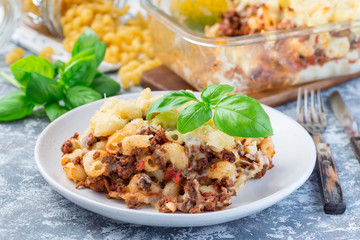 Macaroni casserole with ground beef, cheese and tomato on a plate, horizontal