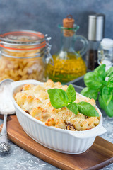 Macaroni casserole with ground beef, cheese and tomato in  baking dish, vertical