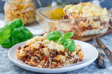 Macaroni casserole with ground beef, cheese and tomato on  plate, horizontal