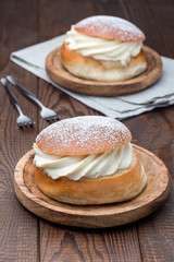 Traditional swedish dessert Semla, also called Shrove bun, with almond paste and whipped cream filling,  vertical