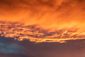 Dramatic orange sky with clouds at sunset. It can be used as a background