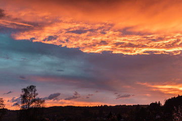 Fototapeta premium Dramatic orange sky with clouds at sunset. It can be used as a background