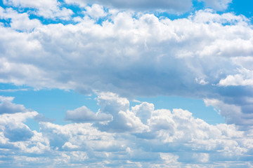 Naklejka na ściany i meble Beautiful white cumulonimbus clouds against the background of the bright blue sky