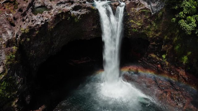 cinemagraph or animated still image of rainbow falls hilo hawaii. a beautiful slow motion aerial shot of a beautiful waterfall with rainbow