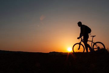 Man with mountain bike at sunrise