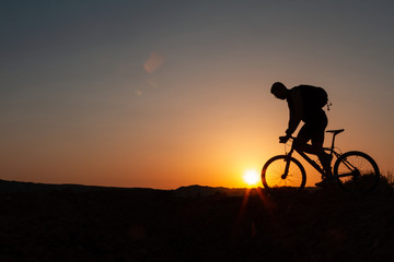 Obraz premium Man with mountain bike at sunrise