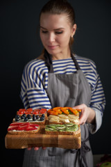 Pretty woman serving healthy food on cutting board