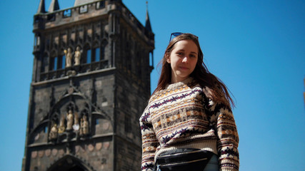Young woman posing for photo and on the background of the tower. Czech, Prague