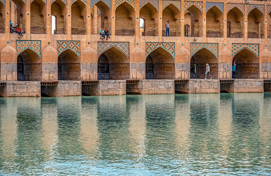 22/05/2019 Isfahan, Iran, people are walking on Khaju Bridge with plenty of arches over Zayandeh river, and make a selfie on smartphone in twilage time