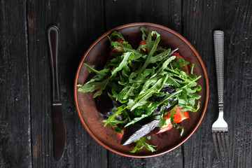 Obraz na płótnie Canvas juicy leaf salad with ripe cherry tomatoes arugula basil cucumbers fragrant spices olive oli