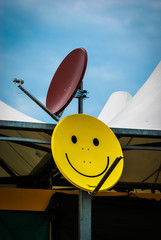 Il simbolo dello smile dipinto su una parabola per la televisione via satellite 