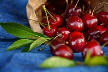 sweet cherry in a kraft paper bag on a blue linen towel