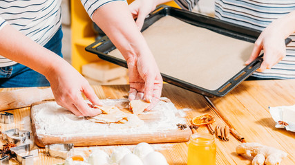 Home culinary course. Cropped shot of women using sheet pan to bake gingerbread biscuits.