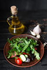 raw food vitamin vitamin salad laid out on a clay plate tomatoes cucumbers basil arugula