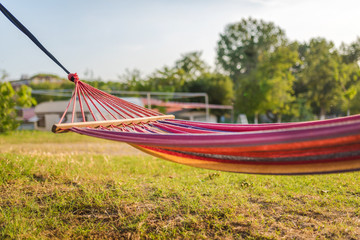 Colorful hammock and a green meadow in a summer day