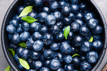 Bowl with ripe blueberry on table, closeup