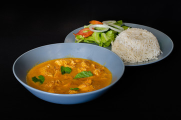 Durban cuisine: A spicy coconut chicken curry. The dish is served with rice and salad and garnished with a few mint leaves