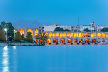 Photo sur Plexiglas Pont Khadjou Khaju Bridge with plenty of people over Zayandeh river is iluminated at dusk with lights, Serving as a dam as well