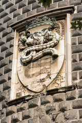 Detail of the Sforza Castle (Castello Sforzesco) with the coat of arms of the noble family of the Visconti with a snake that swallows a human (Biscione). Milan, Lombardy, Italy, Europe