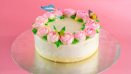 Butter cream of Pink Roses and butterfly decorated on vanilla pond cake on pink background with copy space served in Birthday Party and wedding. Delicious sweet bakery for someone you love.