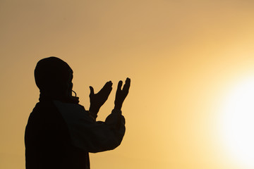 Man praying at sunset mountains raised hands Travel Lifestyle spiritual relaxation emotional concept, Freedom and travel adventure.