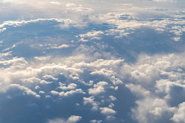 Clouds and blue sky background, viewed from an airplane window