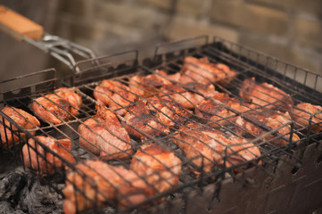 Kebabs pork on the grill with smoke close-up. Chunks of barbecue meat on the fire. Backyard, concept of rest, meat, summer, copy space.